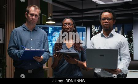 Portrait of technicians in office analyzing machine learning algorithms to prevent AI errors. Teamworking coworkers review code logic to improve artificial intelligence prediction accuracy Stock Photo