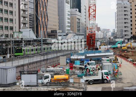 TOKYO, JAPAN - January 17, 2020: The construction site of Shibuya Sakura Stage. A Yamanote Line train is running next to it. Stock Photo