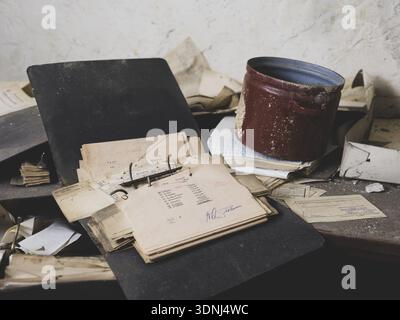 Folders, forms and an old pot on a table in a former GDR factory, Lost Place, Saxony-Anhalt, Germany Stock Photo