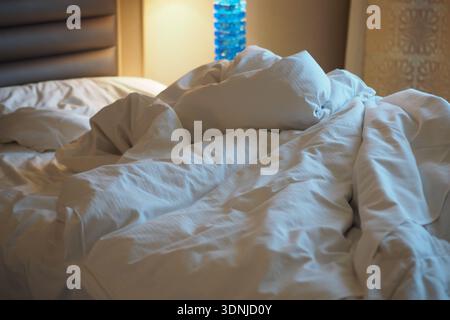 Bedding on a hotel bed after guests checked out Stock Photo
