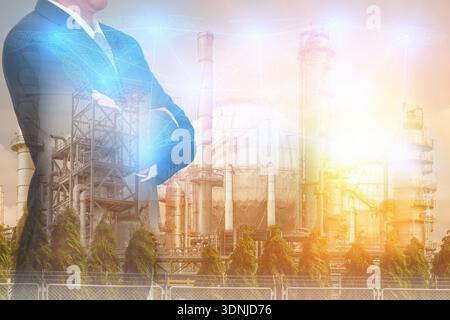Double exposure of Businessman arms crossed and stand up,digital light networking world map, Electric Generating, fuel oil Factory and Energy Industry Stock Photo