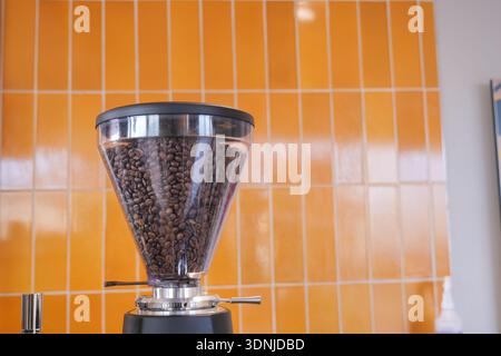 Coffee grinder with beans in cafe setting Stock Photo