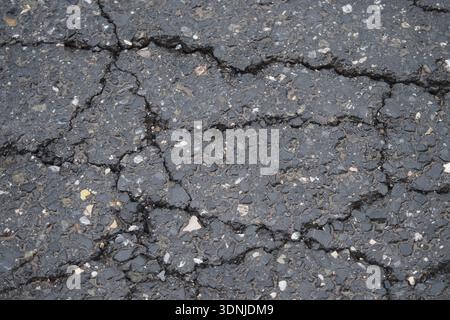 Daytime cracks on urban asphalt surface Stock Photo