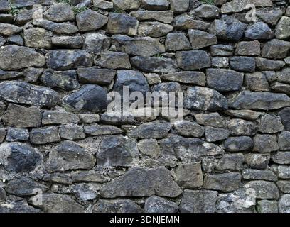 Grungy stone masonry forming a rough background surface. Stock Photo