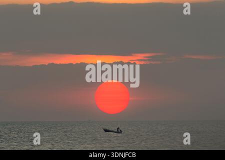 big sunrise on the sea with fishing boat in the morning Stock Photo