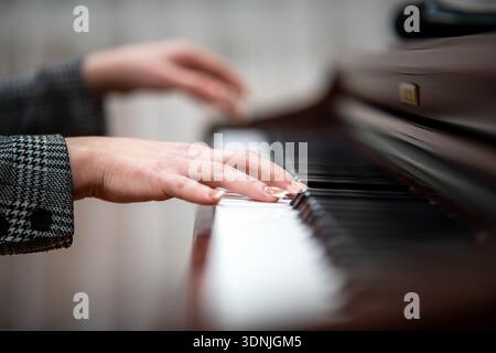 Female hands playing the piano in close-up. Stock Photo