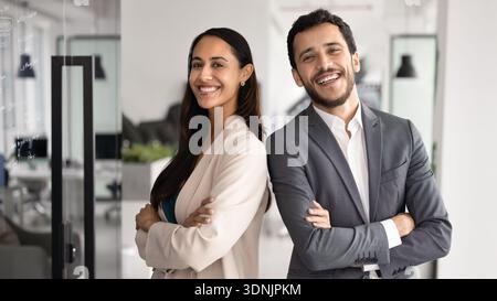 Two multiethnic teammates posing in modern office Stock Photo