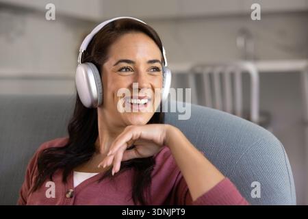 Close-up of happy woman in headphones relaxing on sofa Stock Photo