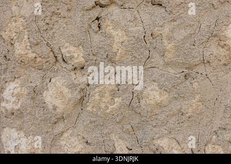 Authentic sandstone wall texture with aged surface and handmade plaster. Warm neutral background for modern design. Stock Photo