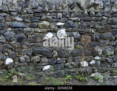 Distressed Historic Dry Stone Wall Masonry Texture with Greenery Stock Photo