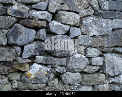 Grungy stone masonry forming a rough background surface. Stock Photo
