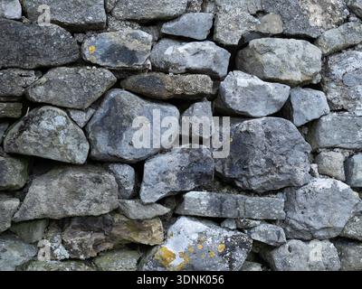 Grungy stone masonry forming a rough background surface. Stock Photo