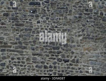 Old exterior dry stone wall with subtle mineral staining. Stock Photo