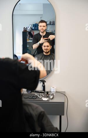 Hairdresser talking with client in barber shop Stock Photo