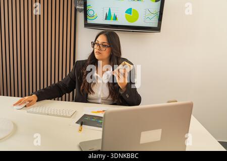 Businesswoman focused on work, managing tasks and analyzing financial data in an office environment Stock Photo