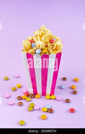 sweet popcorn with dragee on purple background Stock Photo