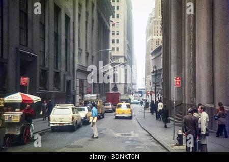Yellow taxi cab driving down Wall Street toward Broadway, Financial District of Lower Manhattan, New York City, USA 1976 Stock Photo
