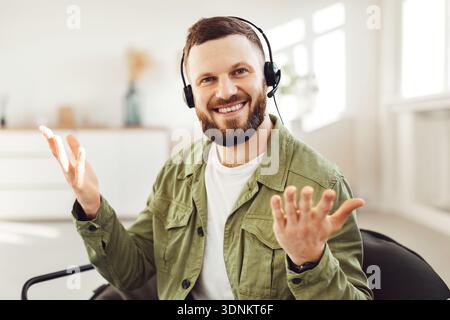 Cheerful Male Freelancer Making Video Call Wearing Headset At Home Stock Photo