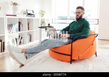 Freelancer Guy Using Laptop Working Online Browsing Internet Sitting Indoors Stock Photo