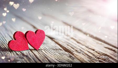 Valentines Day - Two Hearts On Wooden Table With Abstract Glittering Of Lights And Flare Effects Stock Photo