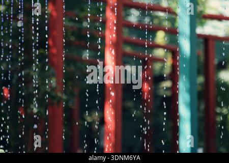 Abstract view of falling water drops with colorful blurred background, creating a fresh and calming atmosphere. Stock Photo