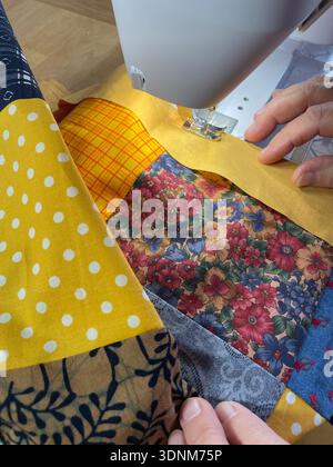 Many colorful square cotton fabrics are sewn together on the sewing machine for a magnificent quilt blanket. Photo Willy Matheisl Stock Photo