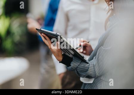 Business professional writes on a clipboard during an indoor meeting setup for planning Stock Photo