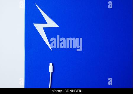 Detailed View Of Lightning Icon On Cable Tip Set Against Bright Blue Backdrop For Contemporary Style Stock Photo
