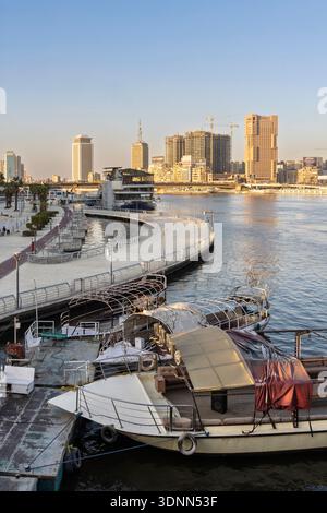 Caior, Egypt - February 4, 2026: A tranquil Cairo waterfront scene featuring a curved promenade, moored boats, and a bustling skyline with constructio Stock Photo