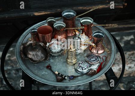 Traditional Bosnian coffee set with copper pots and cups arranged on a metal tray. Morning ritual scene reflects local culture, hospitality, and orien Stock Photo