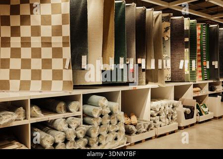 Various rugs and carpets hanging inside a furniture retail store, showing textures, patterns, and interior design options. Belgrade, Serbia - 20 Stock Photo