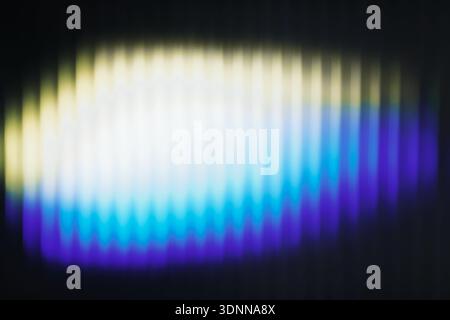 Abstract defocused colorful light shining through ribbed glass surface. Blurred texture with gradient glow and modern artistic mood Stock Photo