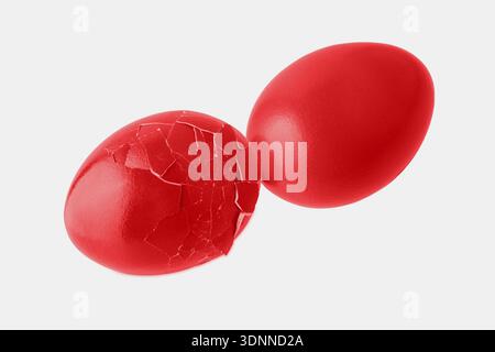Cracked and whole painted in red color natural chicken easter eggs flying isolated on white background. Happy Easter decoration or card element. Stock Photo