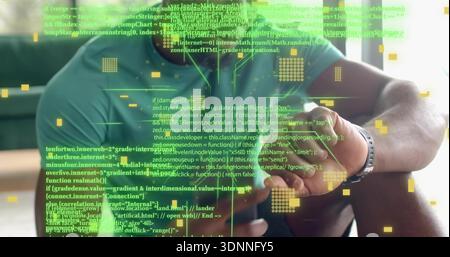 Tapping man wearing teal tee, bracelets and watch, using stylus on tablet on sofa, holographic code Stock Photo