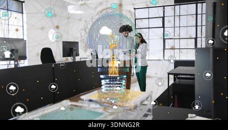 Examining pair in business-casual studying tablet in office near hologram, with network icons Stock Photo
