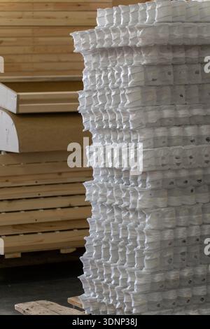 Furniture manufacturing factory interior with a stack of wooden frame, board, and white pocket spring ready for assembly and upholstery in a productio Stock Photo