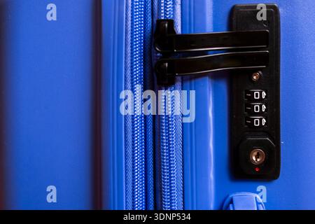 Close-up of a blue suitcase showing a secure combination lock and zipper mechanism. Ideal for travel security, highlighting safety and the reliability Stock Photo