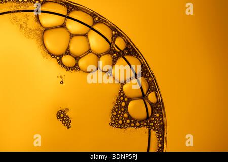 A striking macro image showcasing a cluster of soap bubbles on a vibrant orange backdrop. The bubbles create intricate patterns and reflections, highl Stock Photo