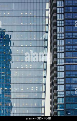 Contemporary urban architecture in Canada featuring sleek modern high-rises with reflective glass facades. The symmetrical design and reflections crea Stock Photo