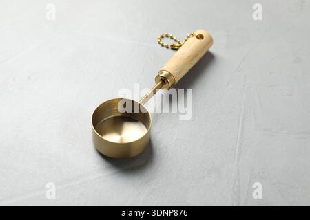 Golden scoop on gray textured table, closeup Stock Photo