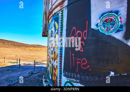 Graffiti Art on Abandoned Metal Structure in Sunlit California Desert Stock Photo