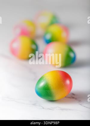 Painted natural easter eggs on a light marble background. One egg closeup Stock Photo