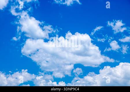 Photograph of white cumulus clouds drifting across a bright and vibrant blue sky in the Blue Mountains in NSW, Australia. Stock Photo