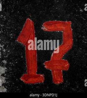 Parking number 17 with screen paint on concrete.red number 17 is written with a brush on concrete. Stock Photo