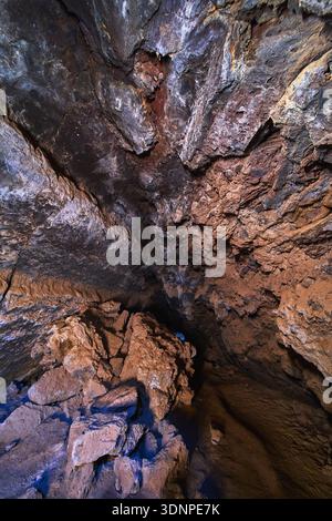 Lava Tube Interior With Volcanic Rock Formations and Shadowed Cavern Ceiling Stock Photo