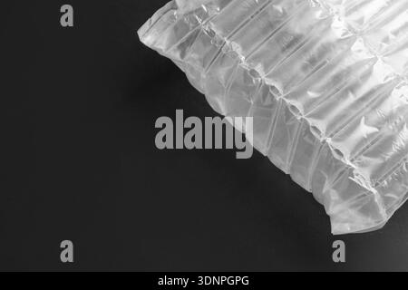 Transparent air buffer packaging on black background, top view. Space for text Stock Photo