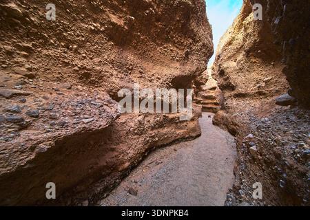 Slot Canyon Path Rugged Sandstone Walls and Sunlit Desert Adventure Stock Photo