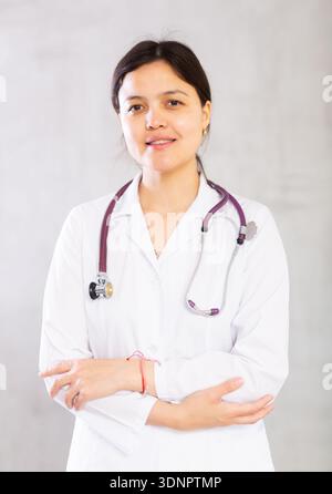 Confident positive female doctor in white uniform with stethoscope Stock Photo