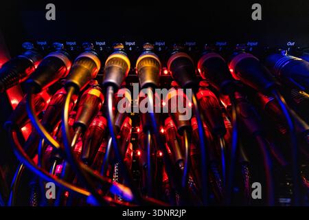Professional Audio XLR Connectors and Cables with Red Indicators on Patch Panel Stock Photo