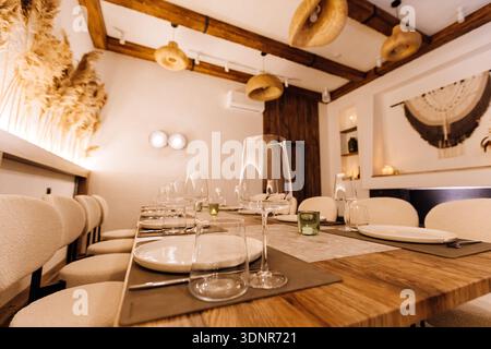Boho private dining room with long table setting, pampas decor and warm light Stock Photo